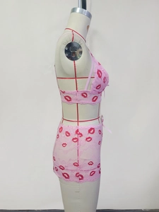 Detailansicht des rosa Spitzen-Lingerie-Sets mit Lippenmuster und Schleifendekor