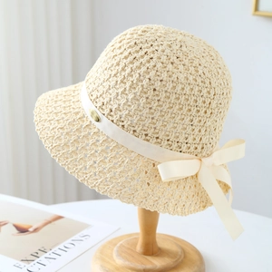 Chapeau de soleil au crochet beige avec ruban crème sur un support en bois