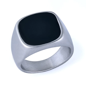 Detail of matte brushed silver finish and black square inlay on men's signet ring