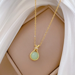 Elegant gold titanium necklace with a round green gemstone pendant in a gift box