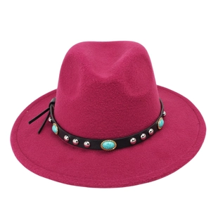 Detail of rose red wool felt fedora featuring turquoise stones and metal studs on leather band