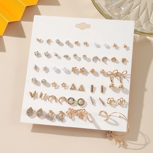 Detailed view of mixed heart and pearl earring set on white display card