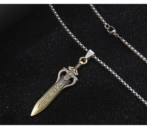 Dettaglio del ciondolo a spada in bronzo vintage con incisioni su catena box argento