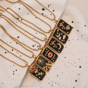 Macro shot of gold tarot necklaces with sun and moon enamel pendants on twisted chains