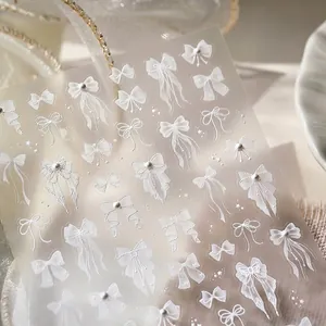 Elegant white 3D bow nail art stickers with relief pattern on a silk background