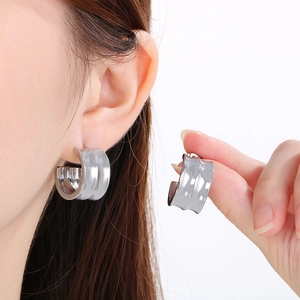 Boucles d'oreilles larges en C en acier inoxydable argenté portées par un mannequin