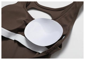 Detail view of the brown yoga bodysuit featuring internal pockets and removable pads