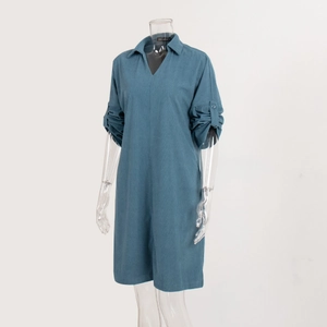 Detailed view of teal v-neck romper featuring buttoned rolled sleeves and twill texture