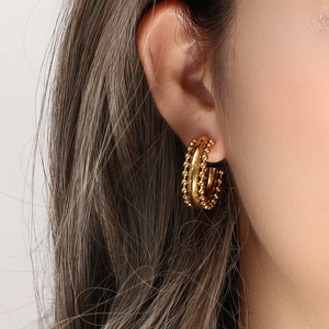 Macro shot of 18K gold plated hoop earrings with bohemian beaded texture and lace detail