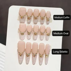 Detail of pink lace nails with gold butterfly charms, rhinestones, and chains decoration
