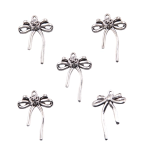 Detailed view of five silver alloy hollow bow pendants for DIY jewelry crafting