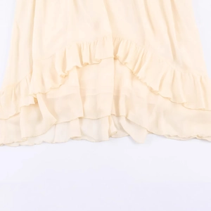 Orlo a balze di un abito midi in chiffon rosa pallido con delicate texture di tessuto
