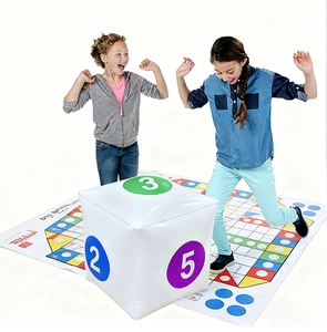 Bambini che giocano con dadi gonfiabili giganti su un grande tappeto da gioco colorato