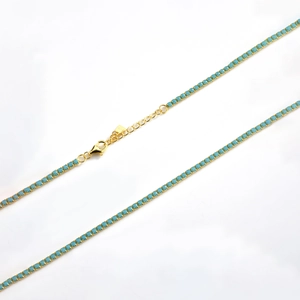 Detail of gold chain necklace with blue turquoise stones and lobster clasp closure