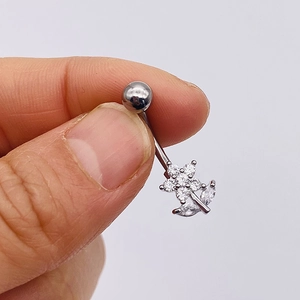 Close-up of silver stainless steel belly ring with sparkling zircon flower design