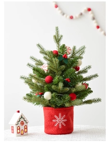 Detailed view of mini Christmas tree featuring red felt pot with white snowflake embroidery