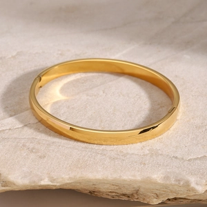 Close-up of golden stainless steel bracelet with polished finish and secure clasp
