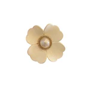 Floral hair claw with cream faux pearl and gold rope trim on white background