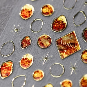 Macro detail of amber style nail stickers with gold accents and star patterns