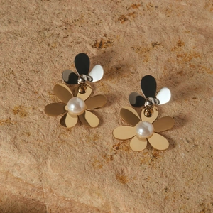 Elegant gold and silver double-layered floral stud earrings with white pearl center on rock