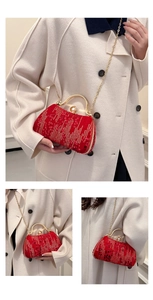 Detail of red sequin evening clutch with gold handle, pearl knob, and chain strap