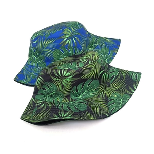 Women's reversible sun bucket hat with green tropical palm and monstera leaf prints