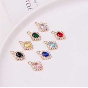 Macro detail of oval gemstone pendants with gold plated cubic zirconia sun flower setting