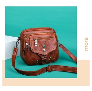 Détail du sac bandoulière vintage marron en similicuir avec rivets et plusieurs fermetures