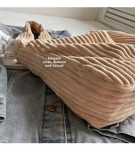 Detail view of beige corduroy tote bag showing soft ribbed texture on denim jacket
