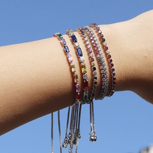 Detail of adjustable colorful zircon bracelets with multi-color stones against a blue sky