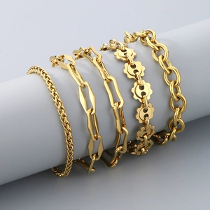 Five-piece stackable 18K gold plated Cuban link bracelet set for women on grey display
