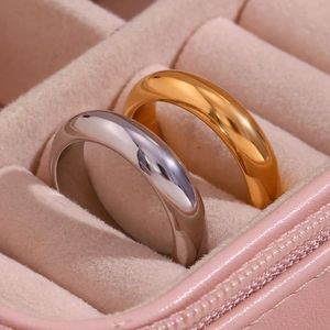 Close-up of gold and silver minimalist band rings inside a pink velvet jewelry box
