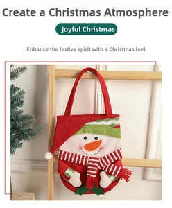 Close-up of a red Christmas gift bag featuring a 3D knit snowman with a striped scarf