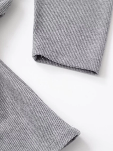 Detailed close-up of grey ribbed knit fabric texture on soft crew neck dress