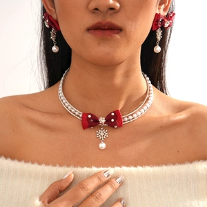 Detail of velvet red bow necklace with snowflake diamond pendant and faux pearls