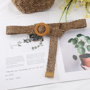 Detail of light brown woven belt with round wooden buckle on a magazine background