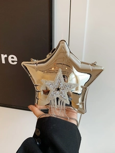 Close-up of silver star-shaped acrylic evening clutch with rhinestone tassels and chain