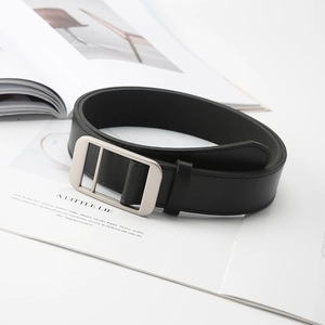 Detail of classic black leather belt with silver matte buckle on a minimalist magazine