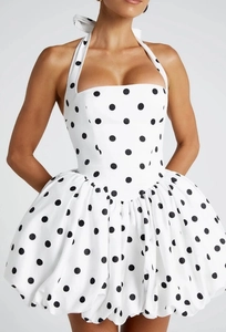 Détail de la robe bustier blanche à pois noirs avec ourlet bouffant et coupe ajustée