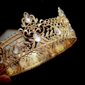 Detailed close-up of golden Baroque crown with intricate hollow patterns and clear crystals