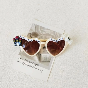 Close-up of heart-shaped Halloween kids sunglasses with Trick or Treat lettering