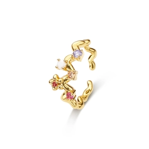 Détail du bijou d'oreille vague plaqué or avec zircons colorés et motif de fleur