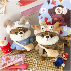 Detail of cute Shiba Inu plush doll with blue sweater and horn headband accessory