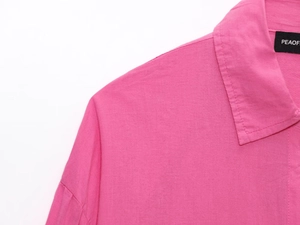 Macro shot of rose pink blouse showing fabric texture and shoulder stitching detail