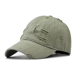 Detail of distressed olive green washed cotton baseball cap with vintage frayed holes