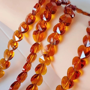 Macro shot of faceted amber crystal heart beads showing transparent texture and glossy finish