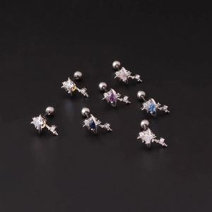 Vue détaillée de sept clous d'oreilles argentés étoile et planète avec zircons colorés