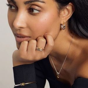 Close-up of mixed metal silver and gold geometric jewelry set worn by a model