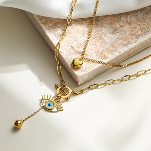 Double-layered gold evil eye necklace with heart pendant and OT toggle clasp closure