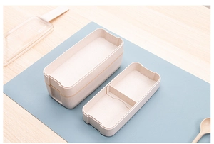 Detail view of double-layer beige microwave lunch box with 900ml capacity on wooden desk